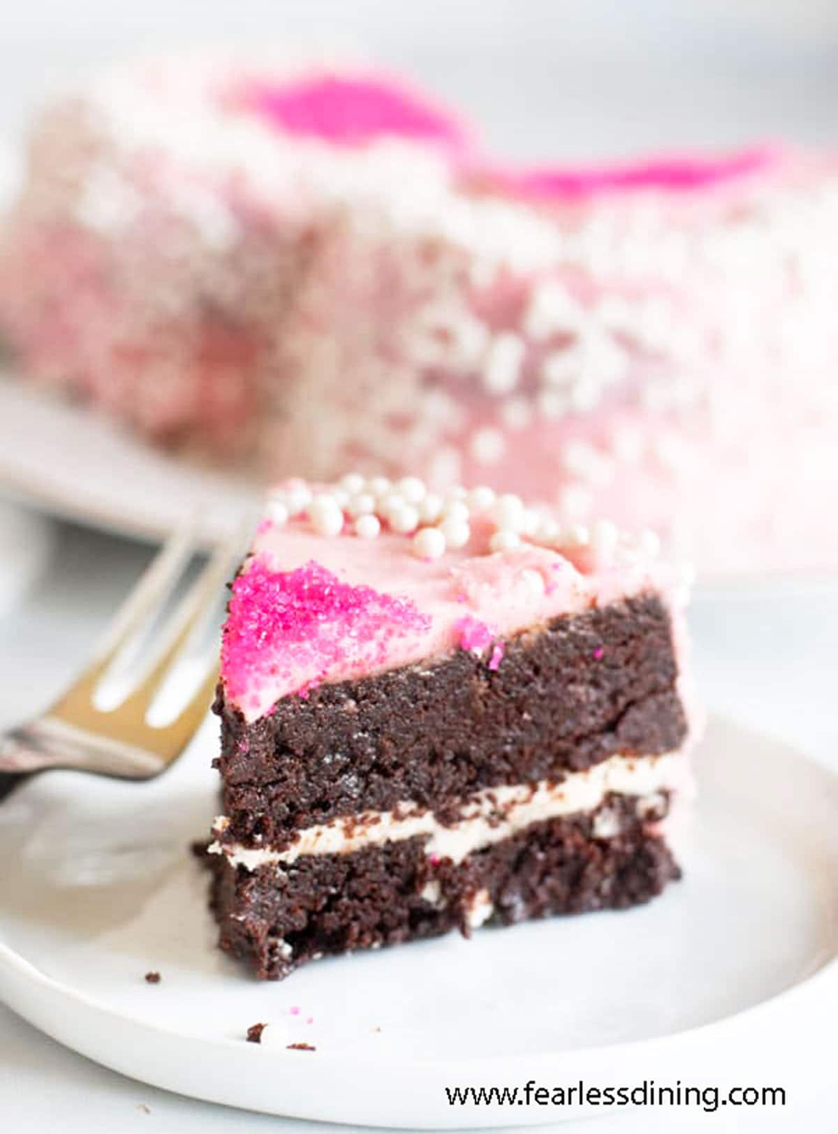 A slice of gluten free brownie layer cake on a plate.