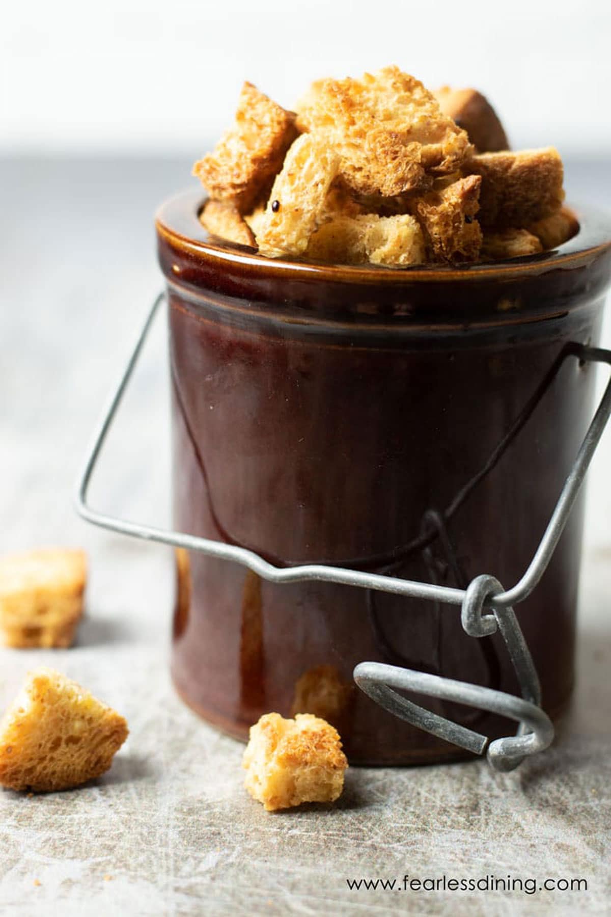 A brown ceramic jar filled with gluten free croutons.