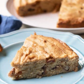 A slice of date nut cake on a light blue plate.
