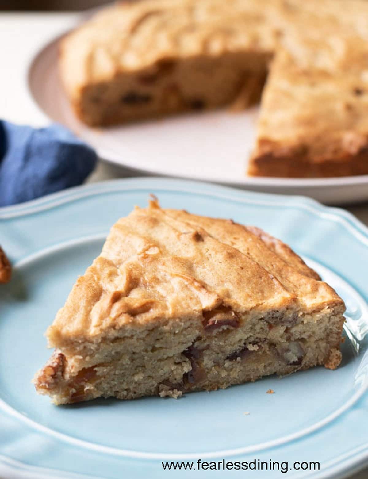 A slice of date nut cake on a light blue plate.