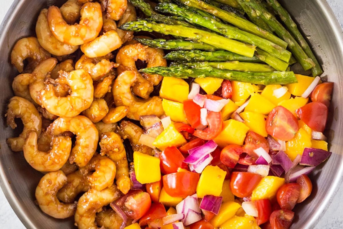 The cooked shrimp and asparagus in the pan.