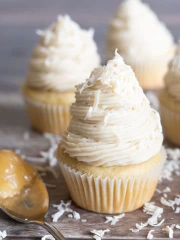 three lemon filled cupcakes topped with buttercream frosting