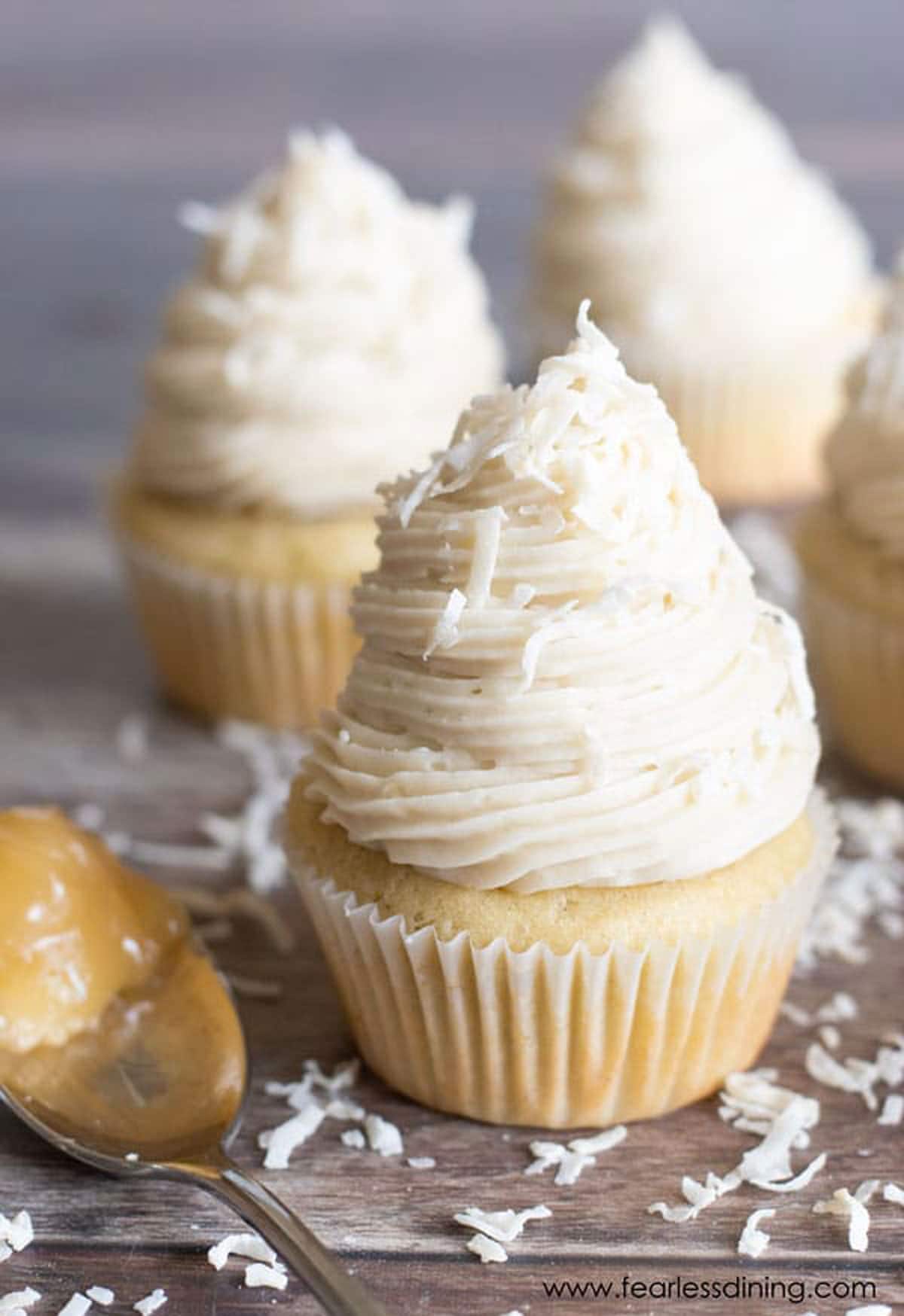Three lemon filled cupcakes topped with buttercream frosting.