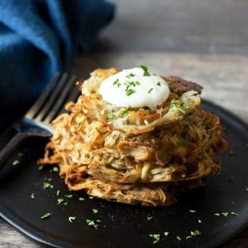 a stack of gluten free latkes on a dark brown wooden plate