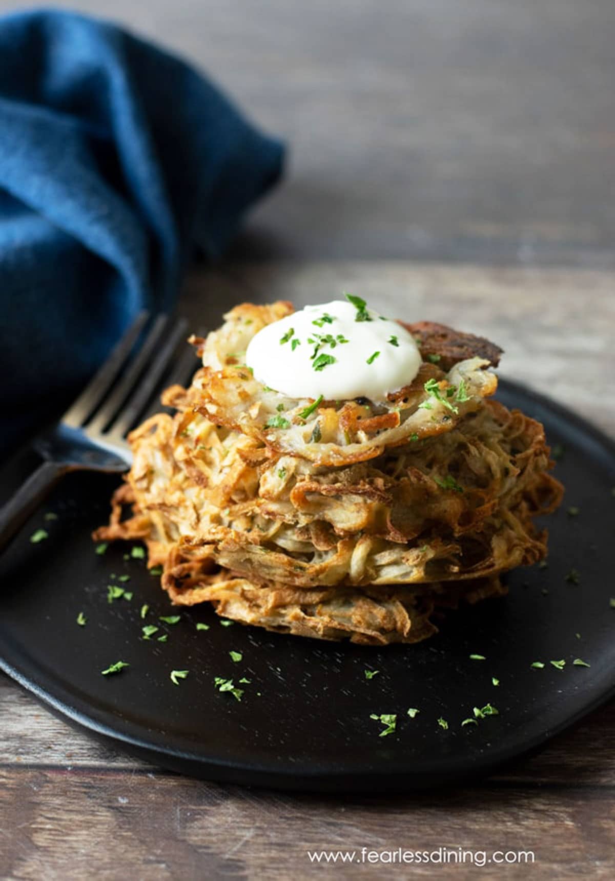 a stack of gluten free latkes on a dark brown wooden plate