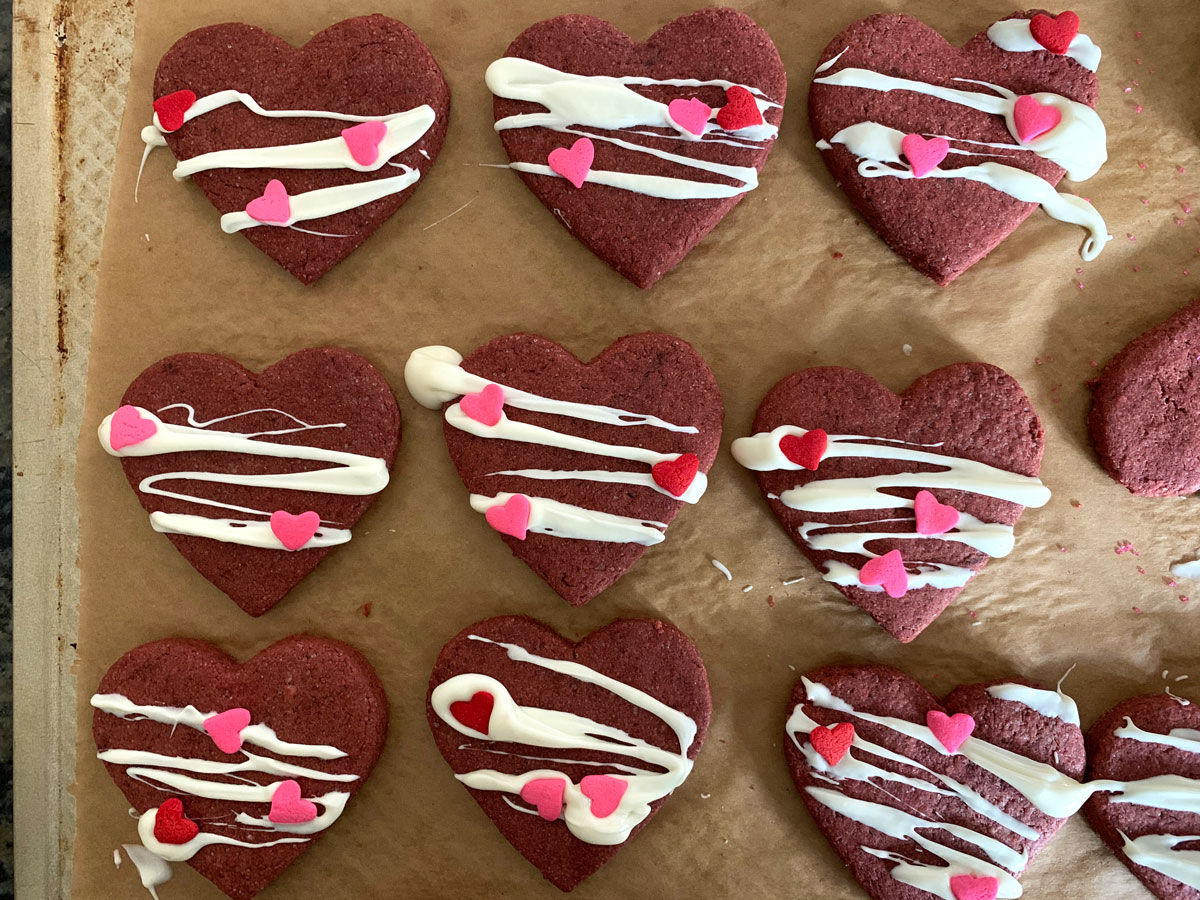 Decorated red velvet heart shaped cookies.