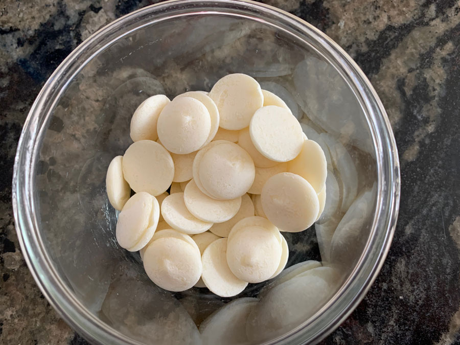 White chocolate melting wafers in a microwave safe dish.