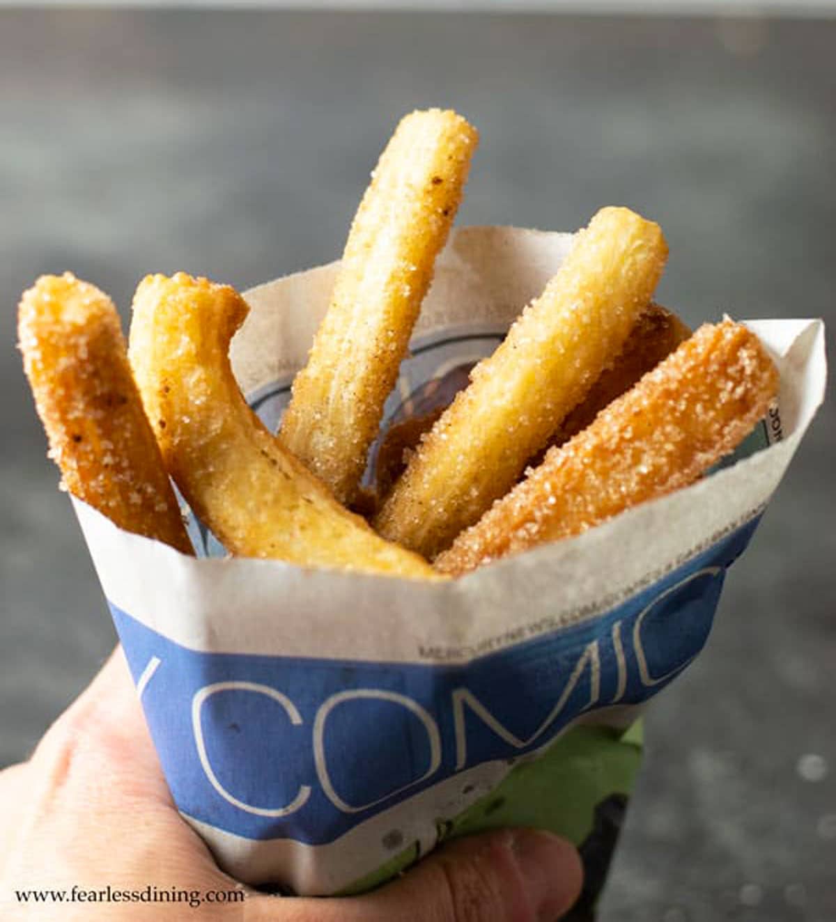 fried churros wrapped in the comic section of newspaper