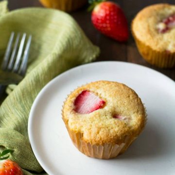 A gluten free strawberry muffin on a white plate.