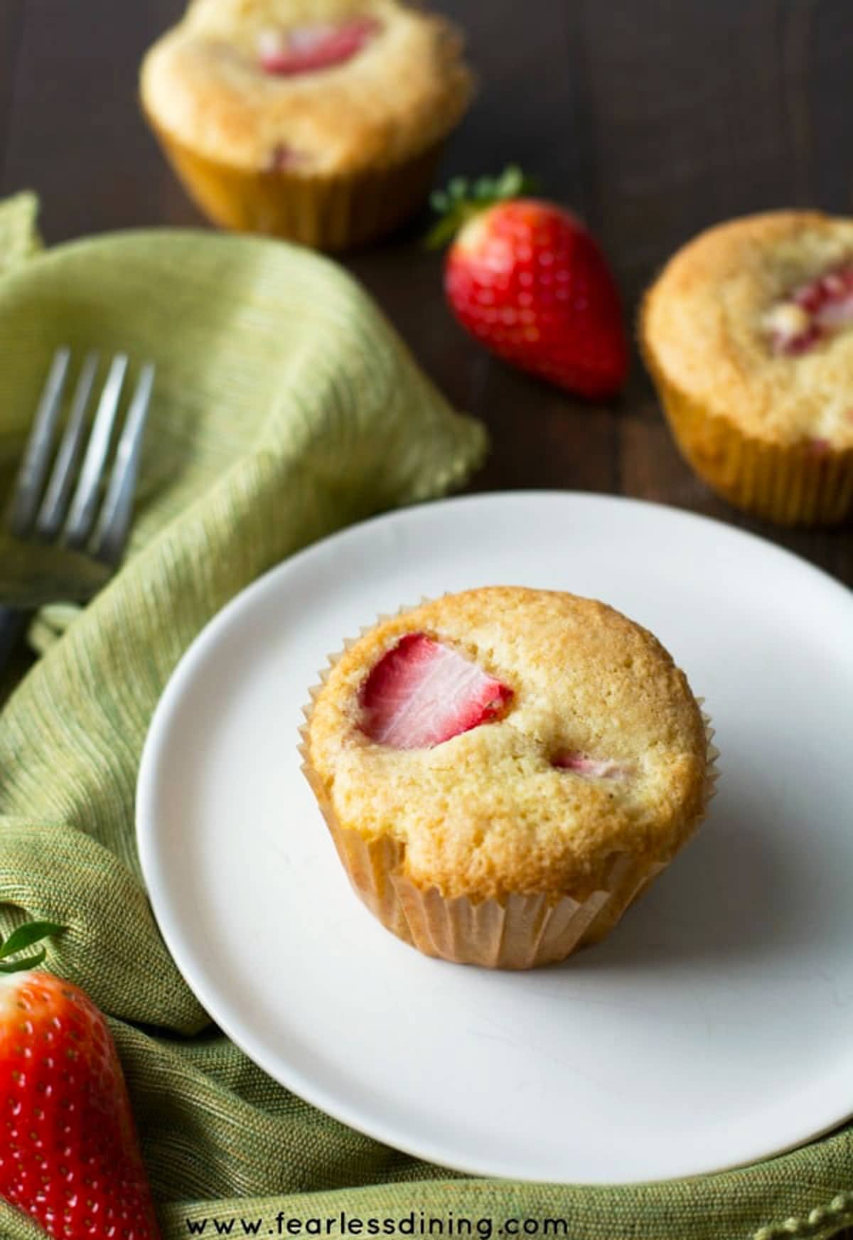 A gluten free strawberry muffin on a white plate.