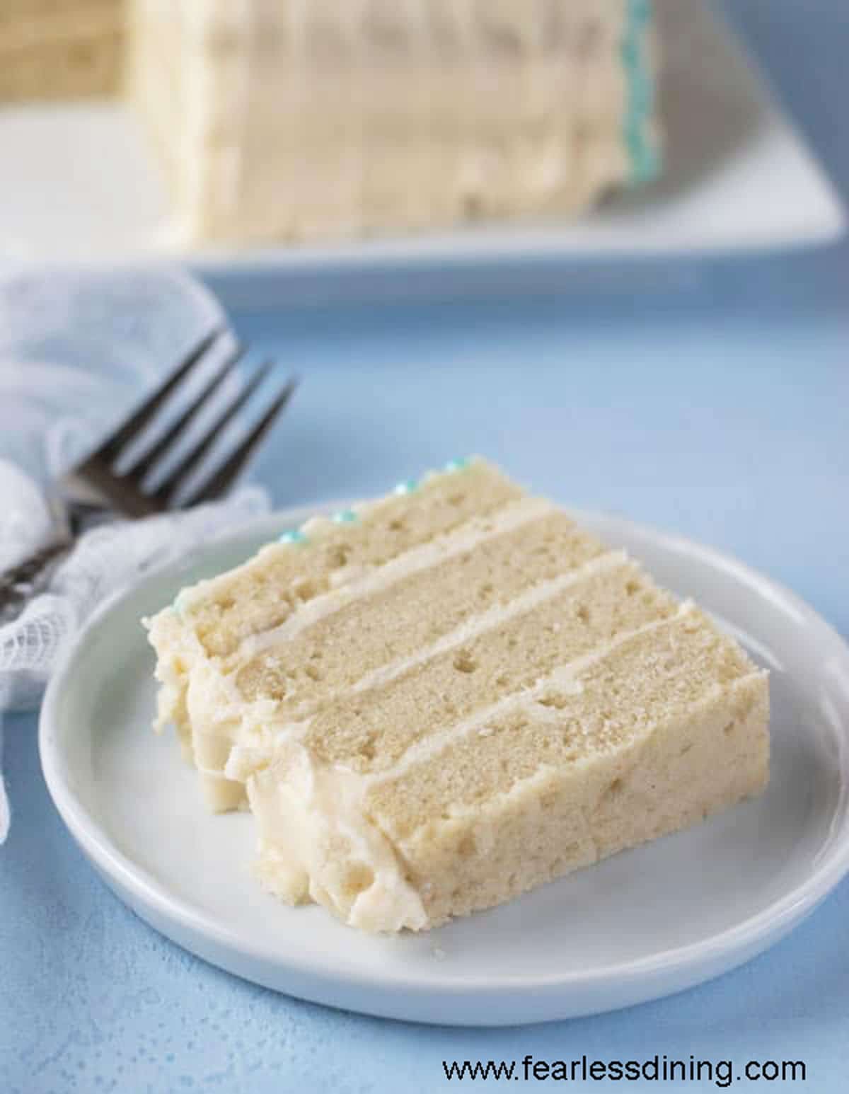 A slice of vanilla layer cake on a plate.