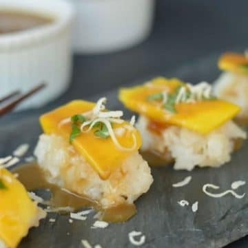 mango dessert sushi on a slate serving platter