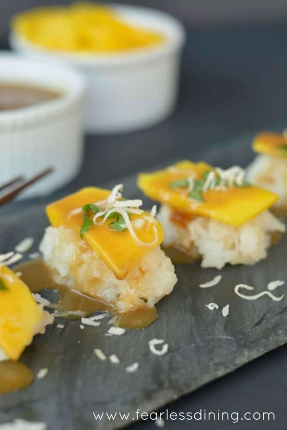 Mango dessert sushi on a slate serving platter.
