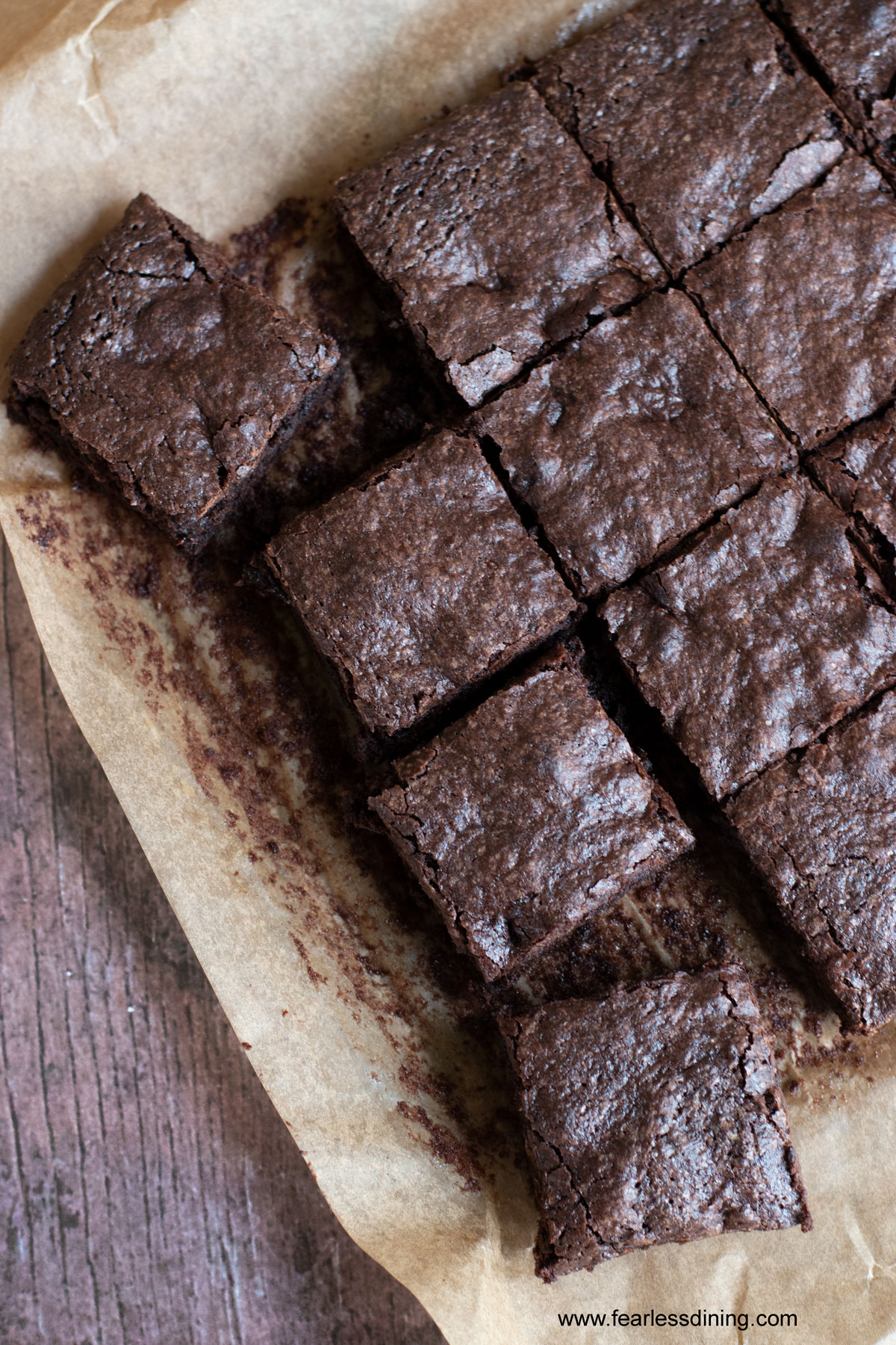 A piece of parchment paper with a batch of cut gluten free dairy free brownies.