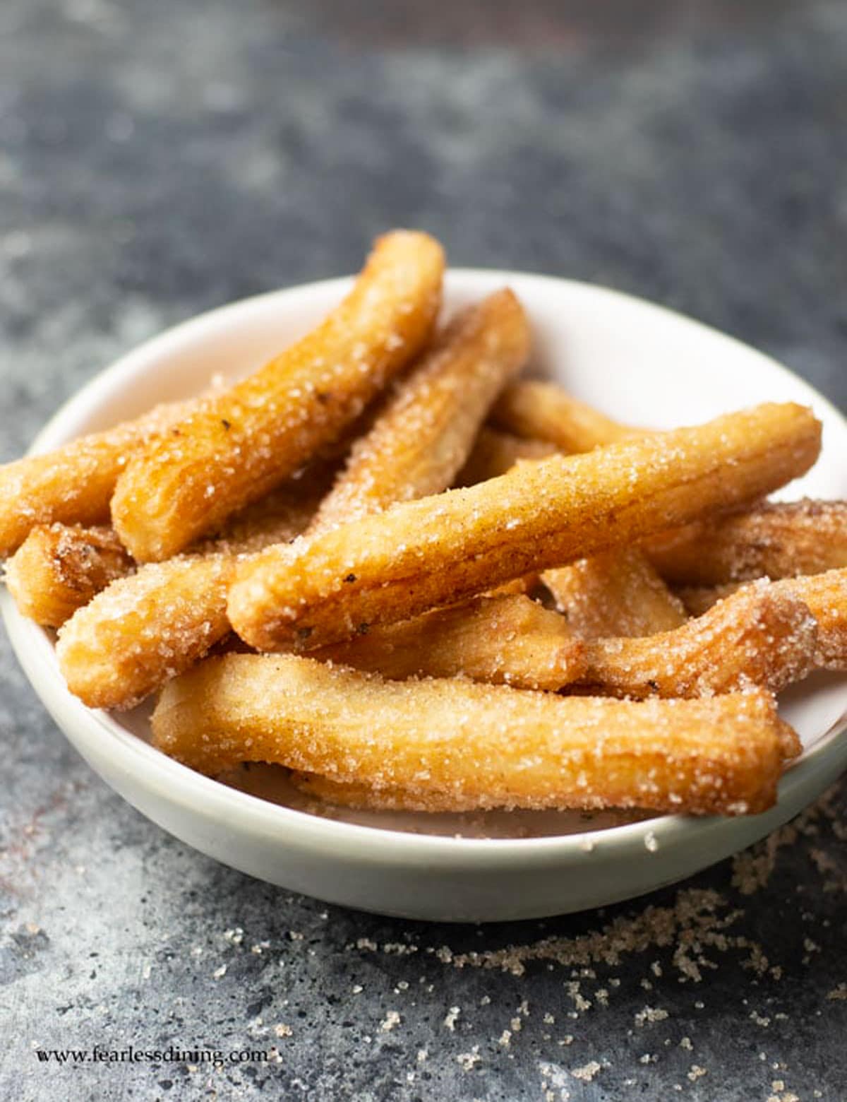 A big bowl full of cooked churros.