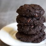 a stack of four chocolate espresso cookies stacked on a plate
