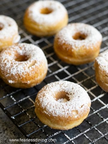 a rack of egg-free donuts with powdered sugar dusted over them