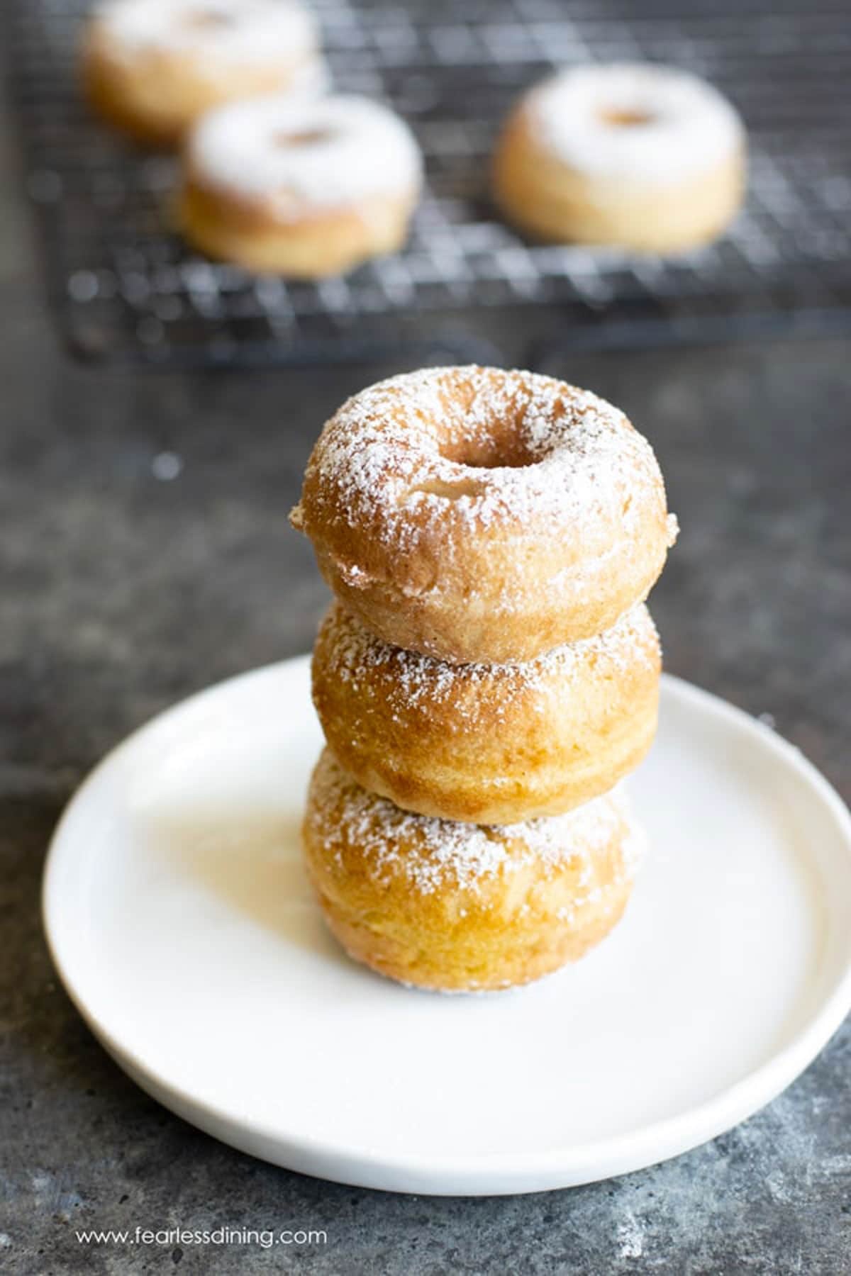 A stack of three egg-free donuts on a plate.