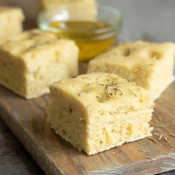 Slices of gluten free focaccia bread on a cutting board.