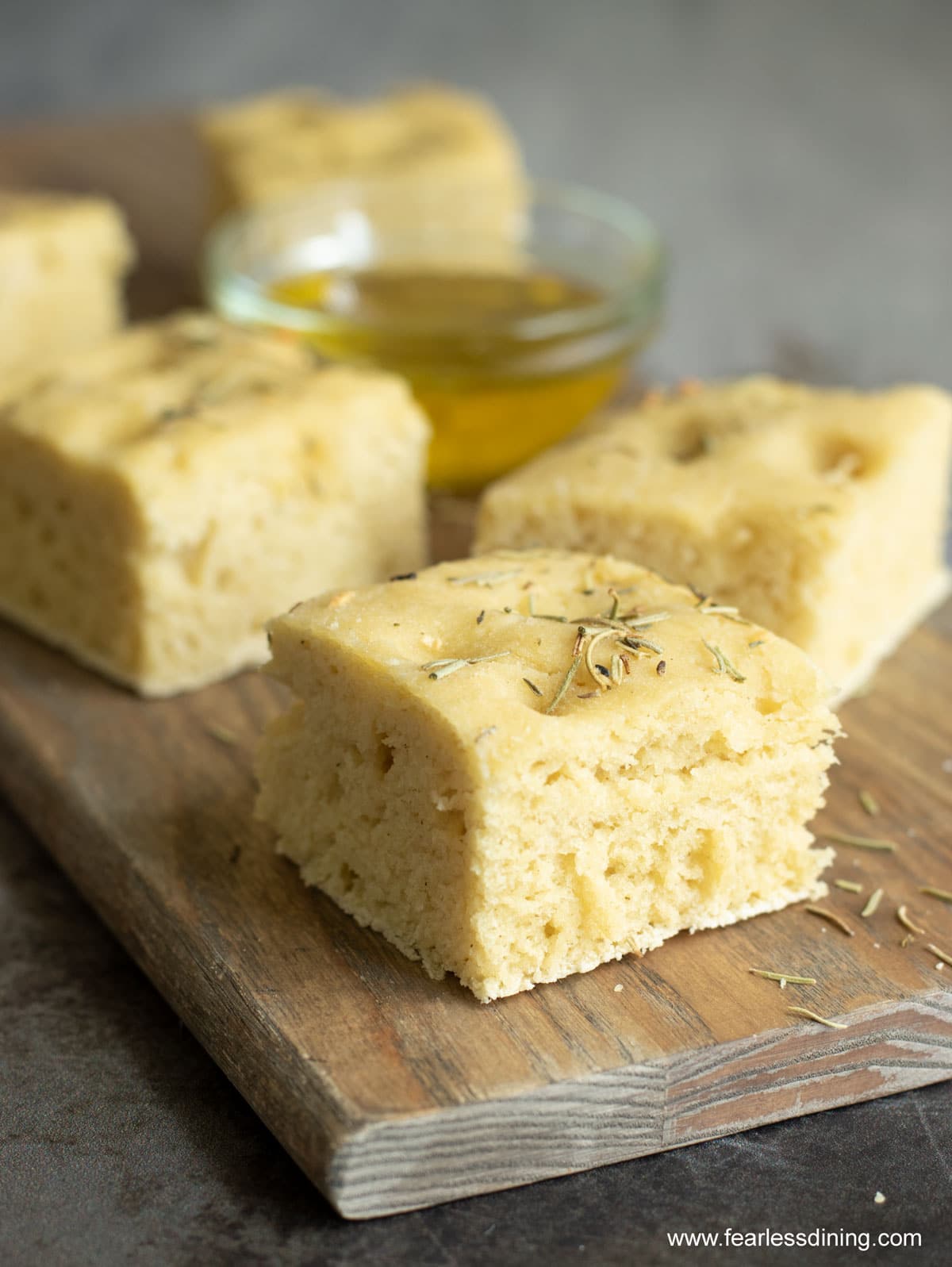 Slices of gluten free focaccia bread on a cutting board.