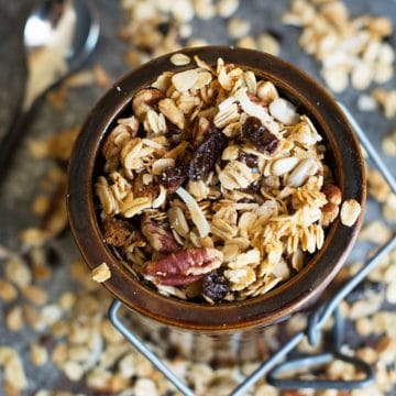 A brown ceramic jar filled with gluten free cinnamon granola.