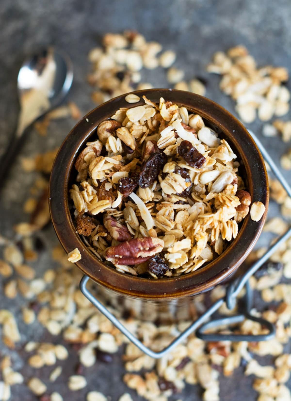 A brown ceramic jar filled with gluten free cinnamon granola.