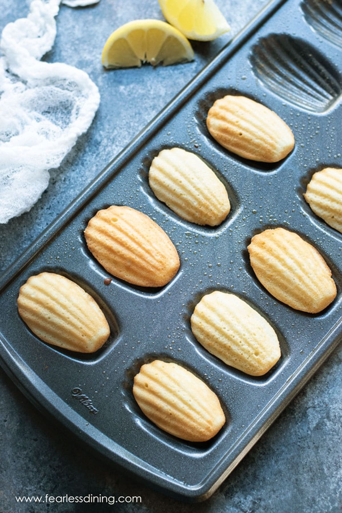 A madeleine pan filled with baked madeleines.