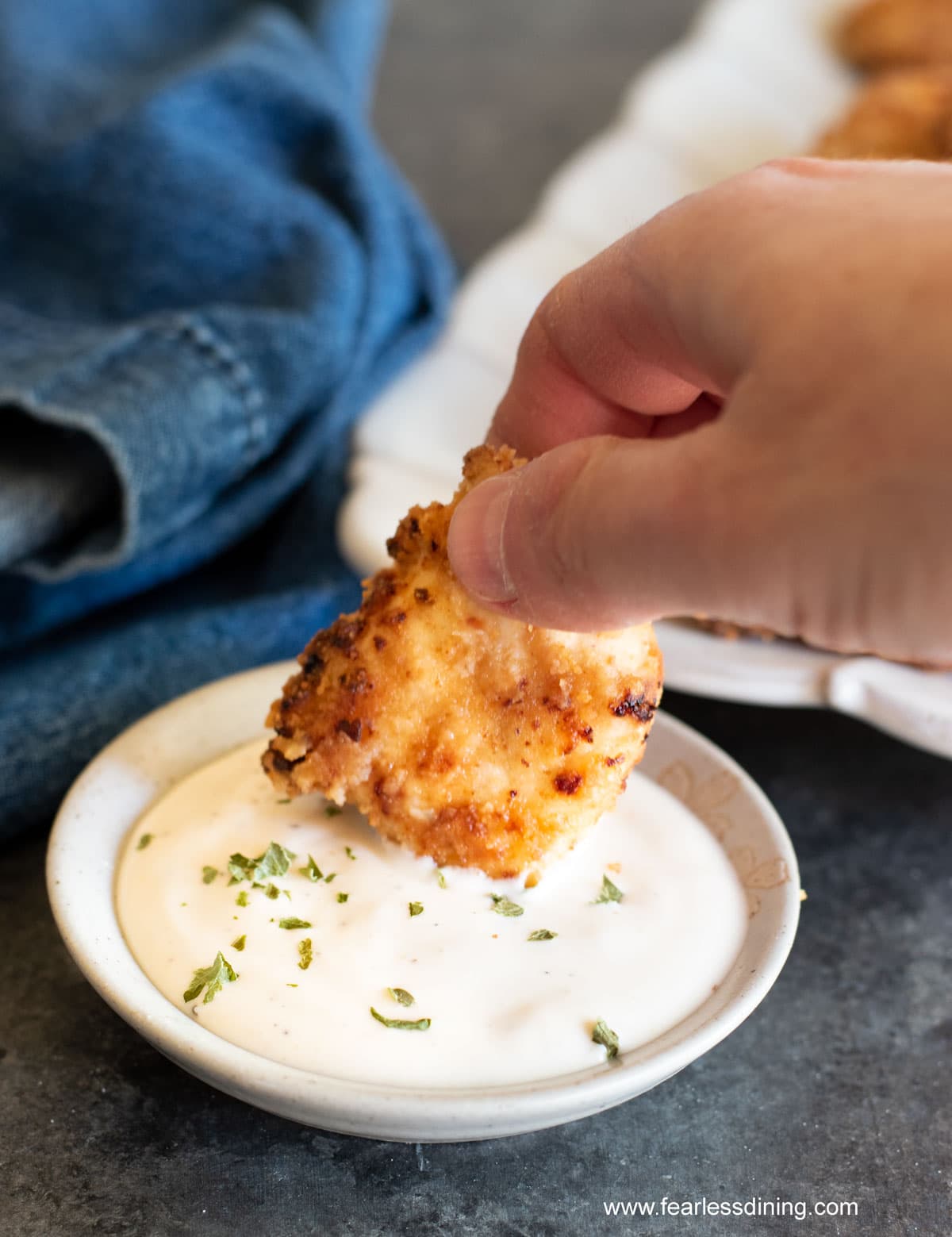Dipping the gluten free nugget in ranch dressing.
