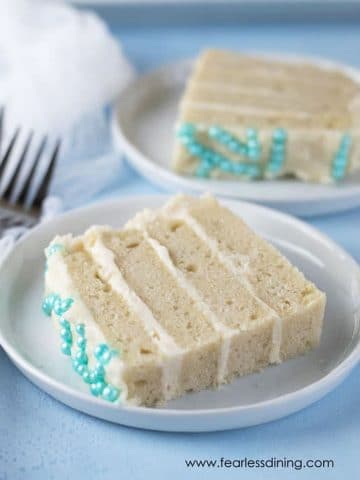two slices of gluten free vanilla cake on white plates