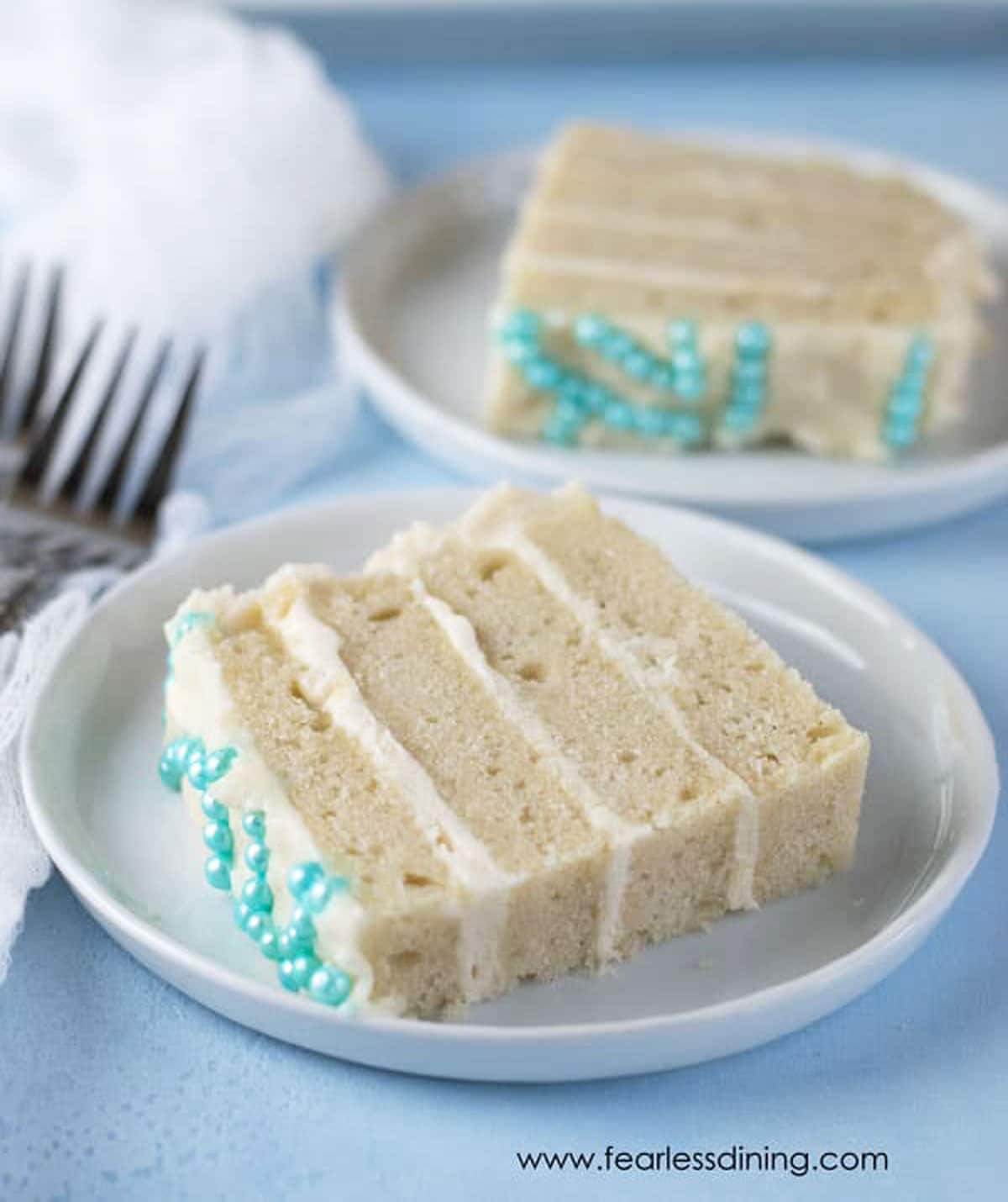 two slices of gluten free vanilla cake on white plates