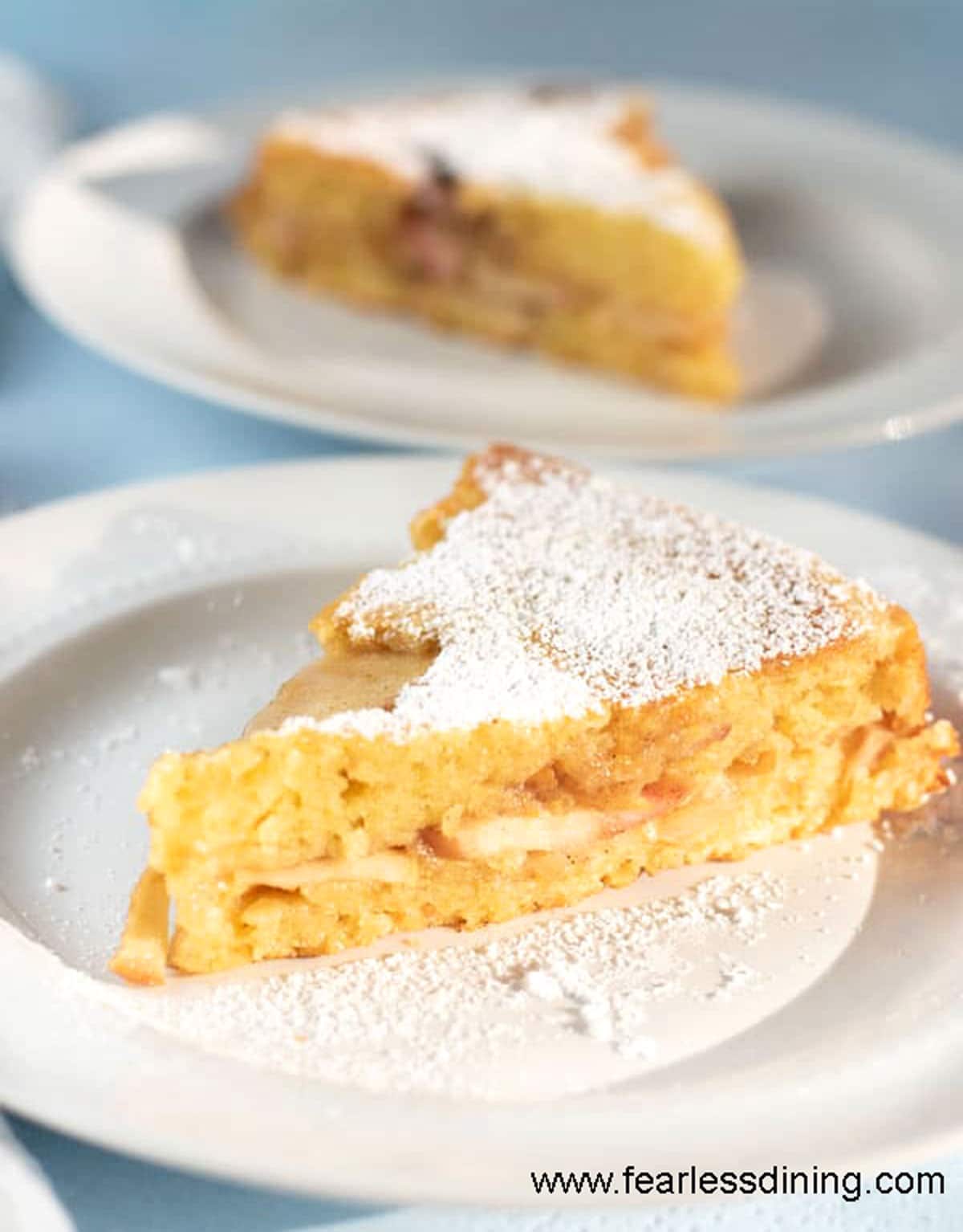 Two slices of apple cake on small white plates.