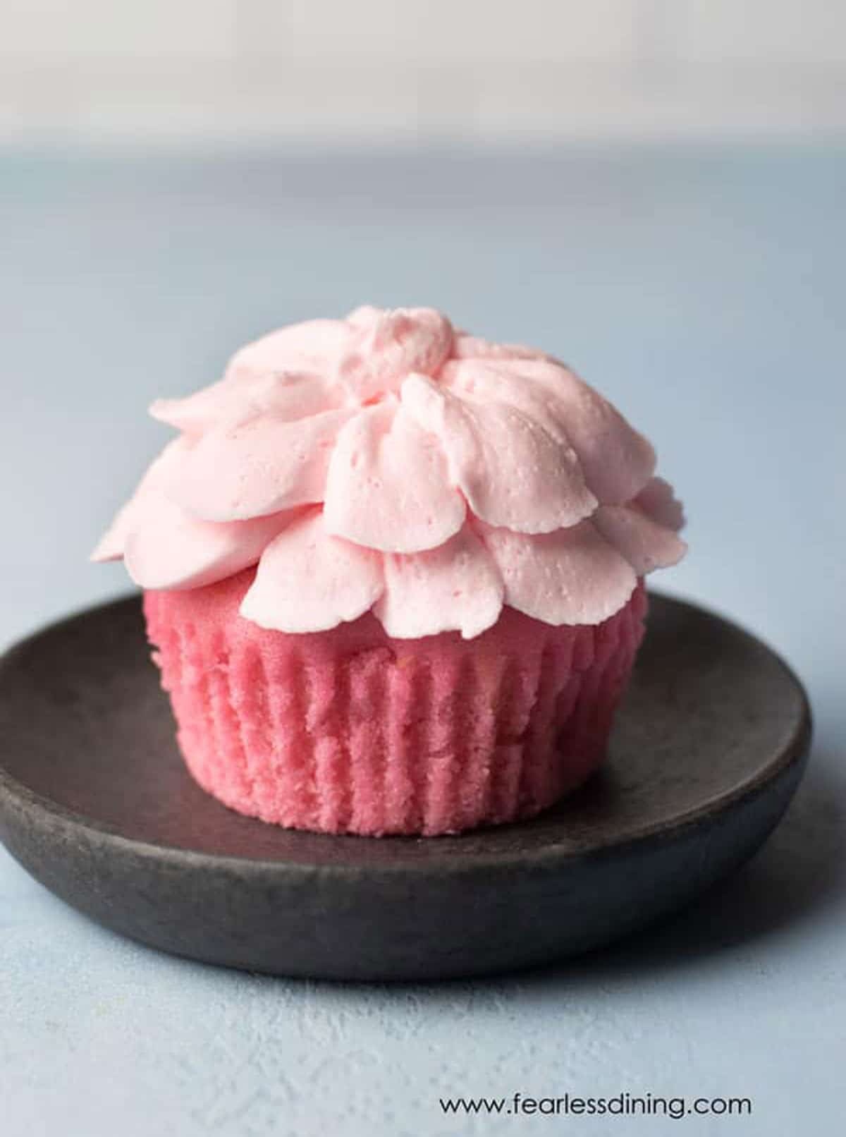 A pink lemonade cupcake frosted like a flower.