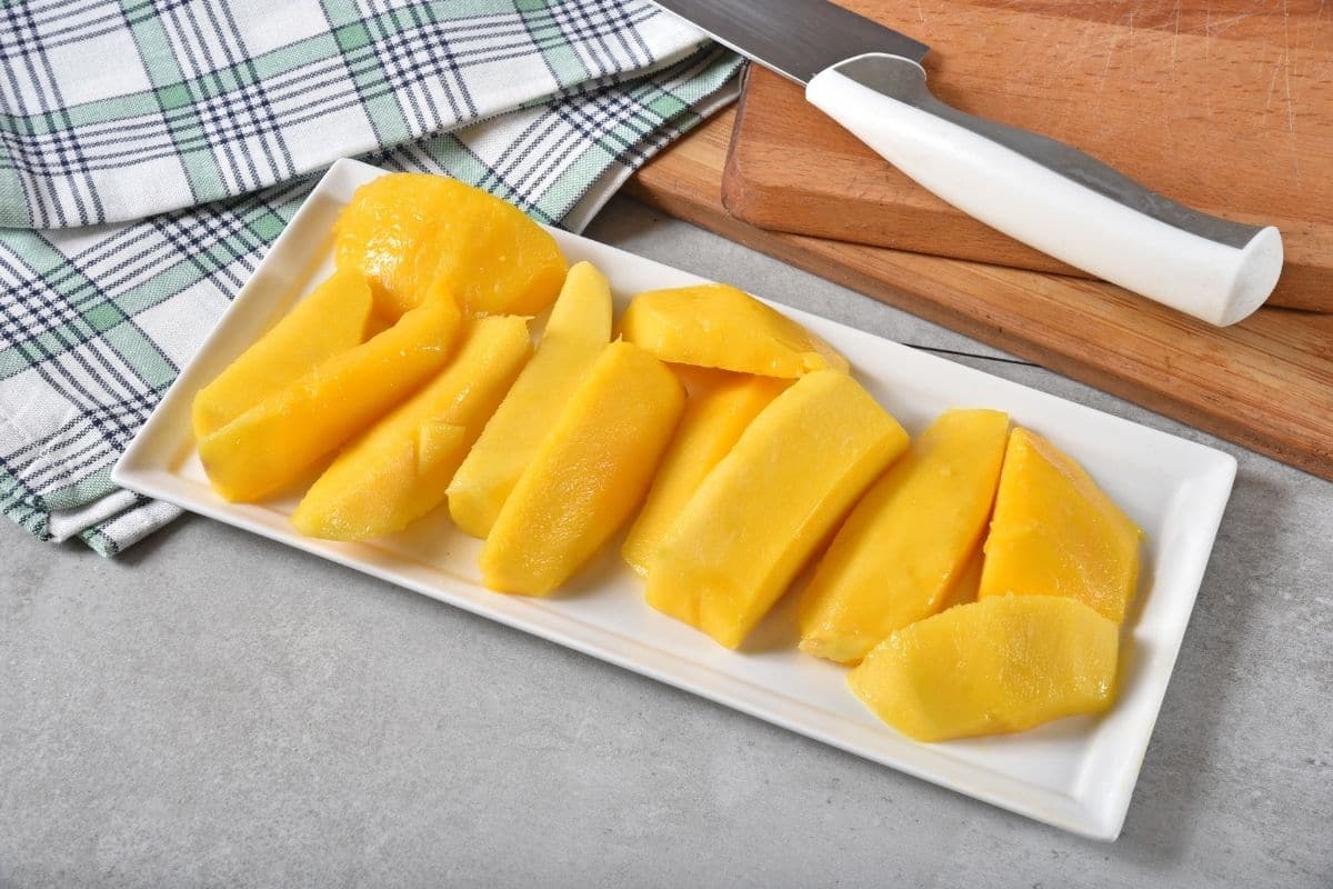 Sliced mango on a rectangular white plate.