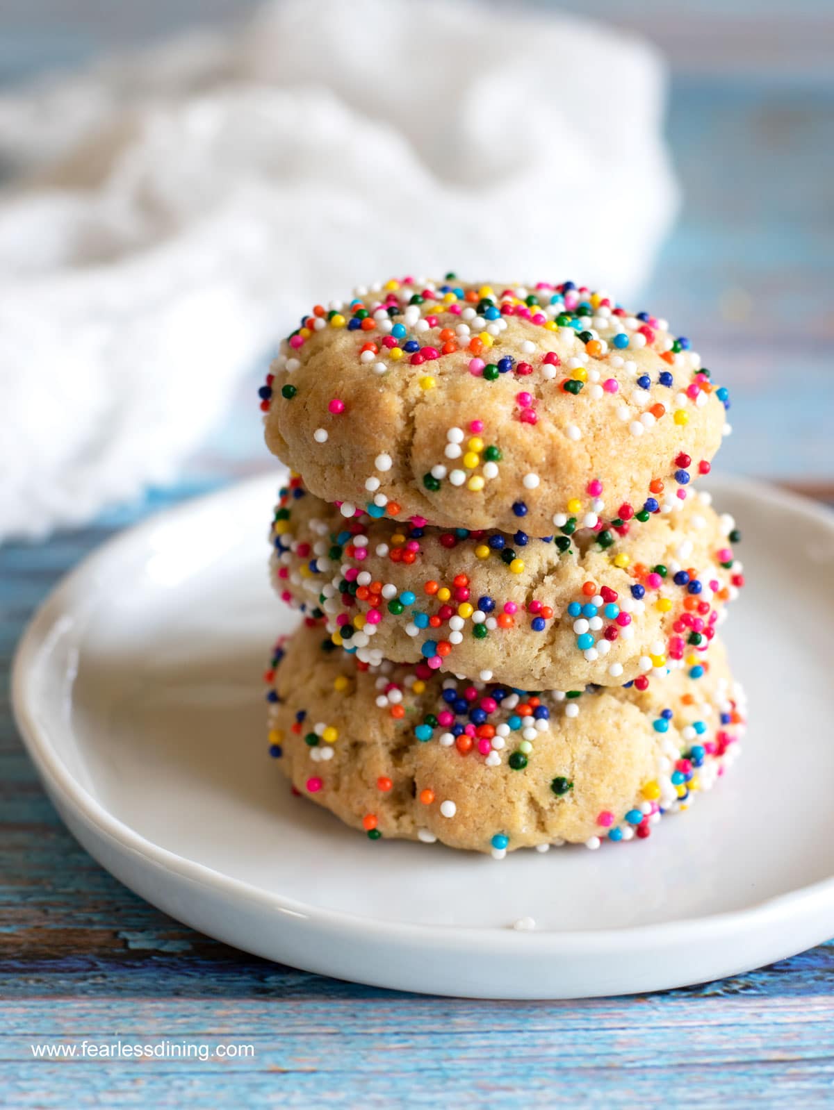 A stack of cream cheese sugar cookies with rainbow sprinkles.