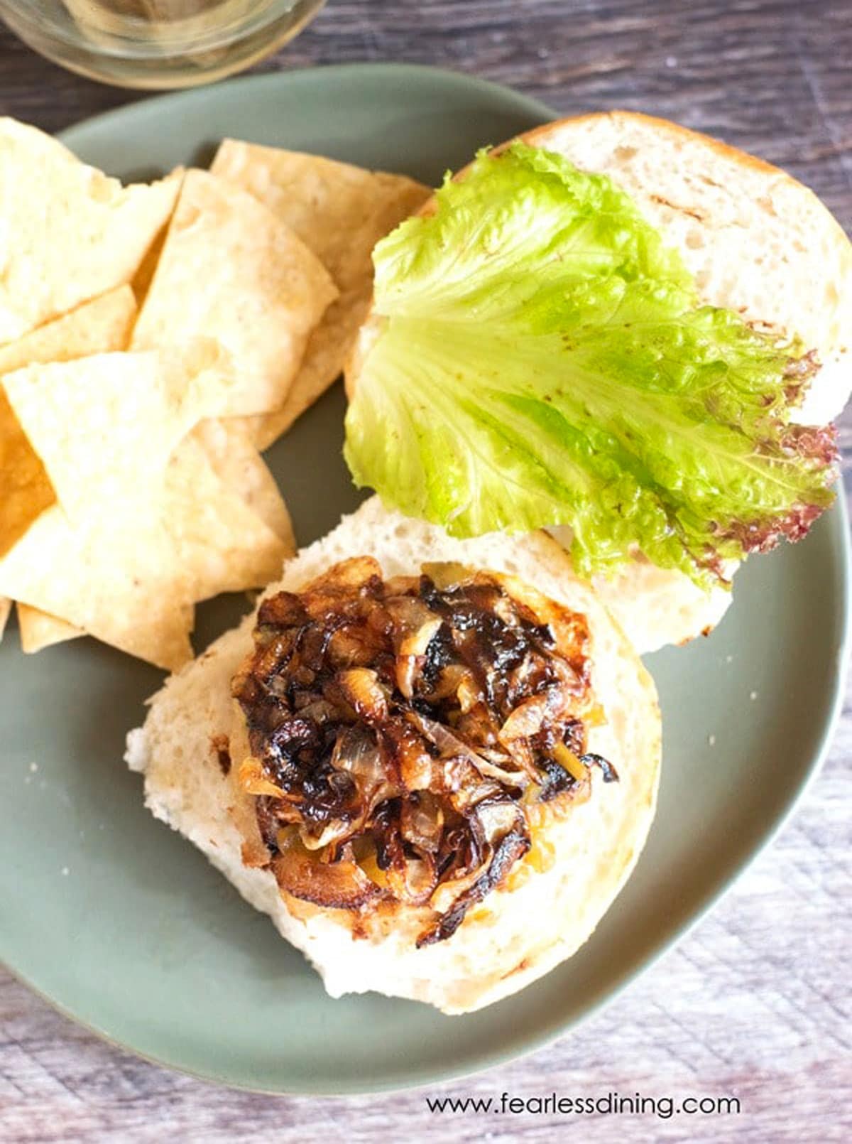 The top view of a ground chicken burger topped with caramelized onions.