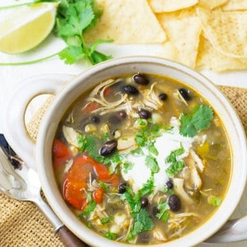 A top view of a bowl of taco soup with corn tortilla chips.