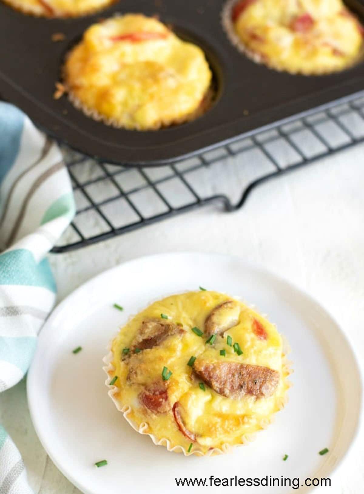 A sausage stuffed egg muffin on a white plate.