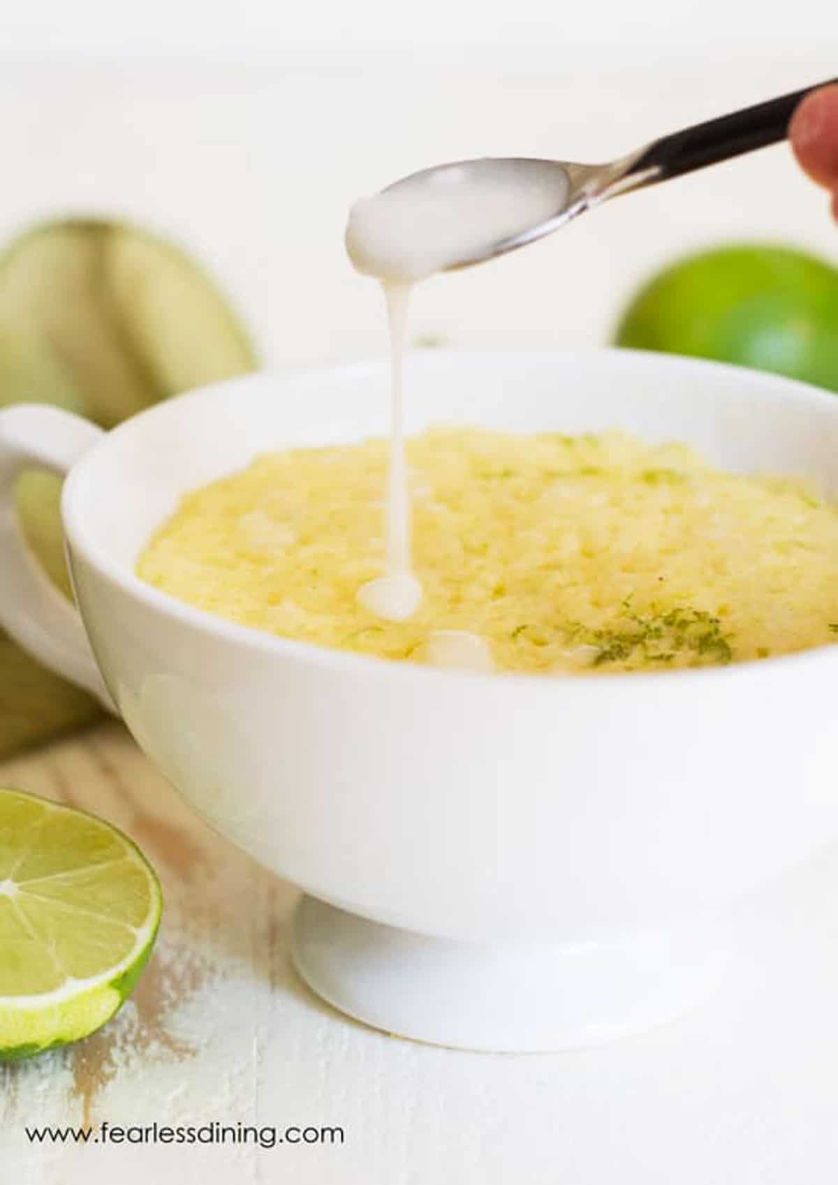 Drizzling icing over a gluten free lime mug cake.