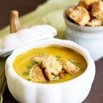 A bowl of roasted acorn squash soup topped with croutons.