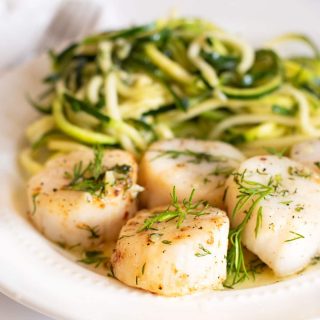 A plate of air fried scallops and zoodles with a garlic butter sauce.