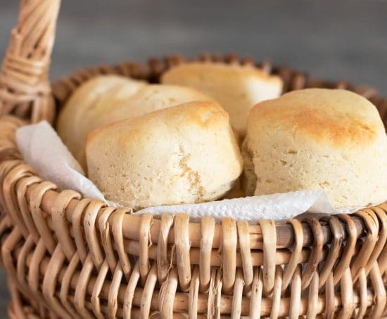 A close up of the baked gluten free rolls in a wicker bread basket.