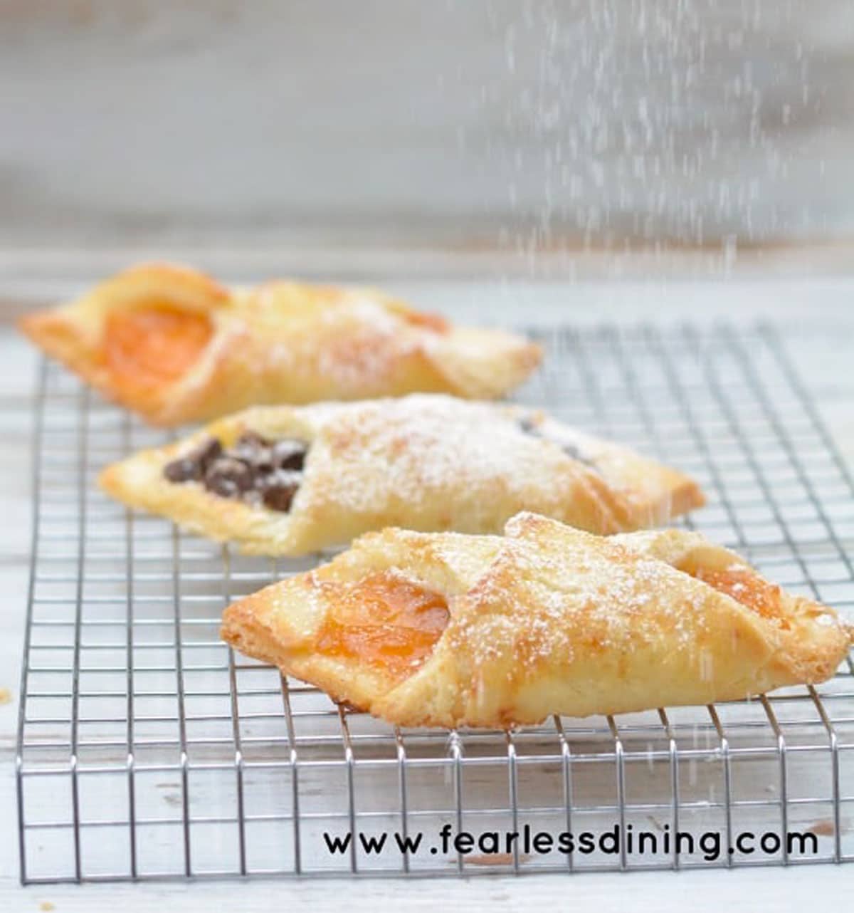 dusting the pastries with powdered sugar