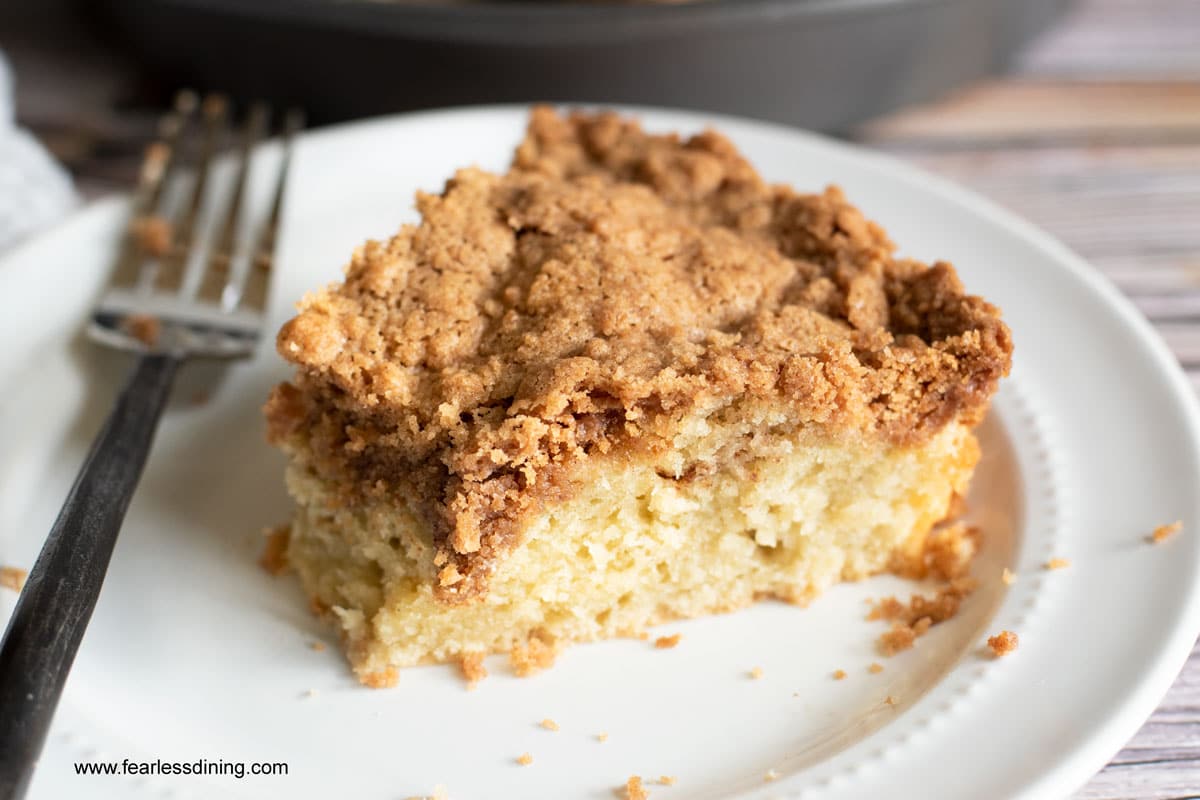 A slice of crumb cake with a piece cut out with a fork.