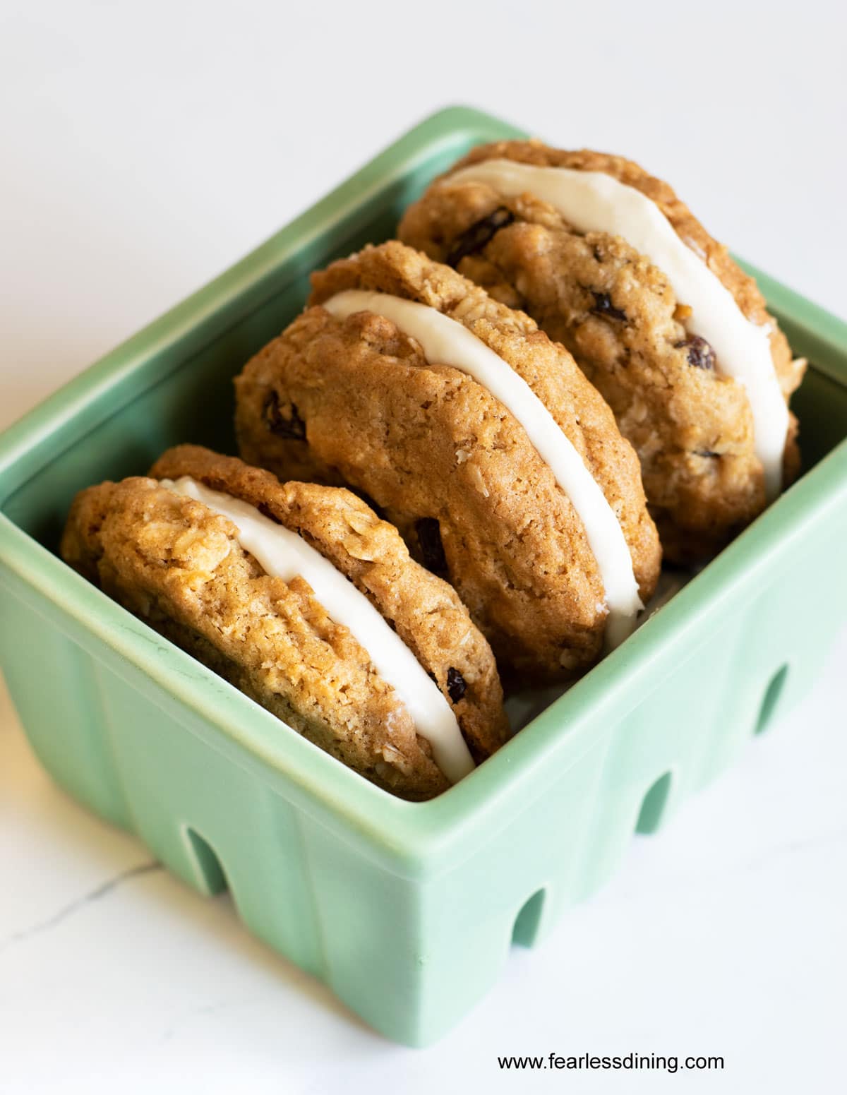 A green square dish with three oatmeal cream pies.