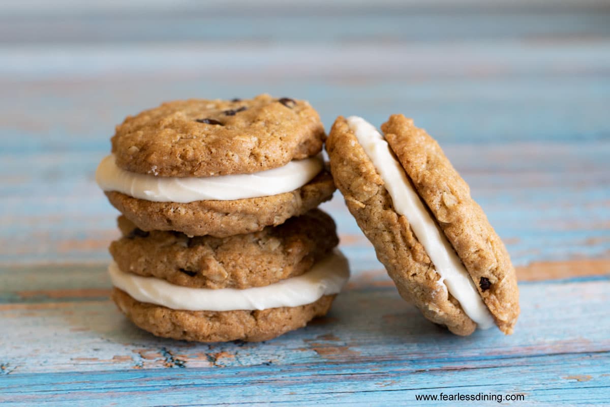 Three homemade oatmeal cream pies on a blue table.