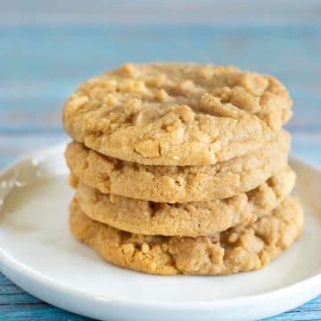 Four gluten free peanut butter cookies on a white plate.