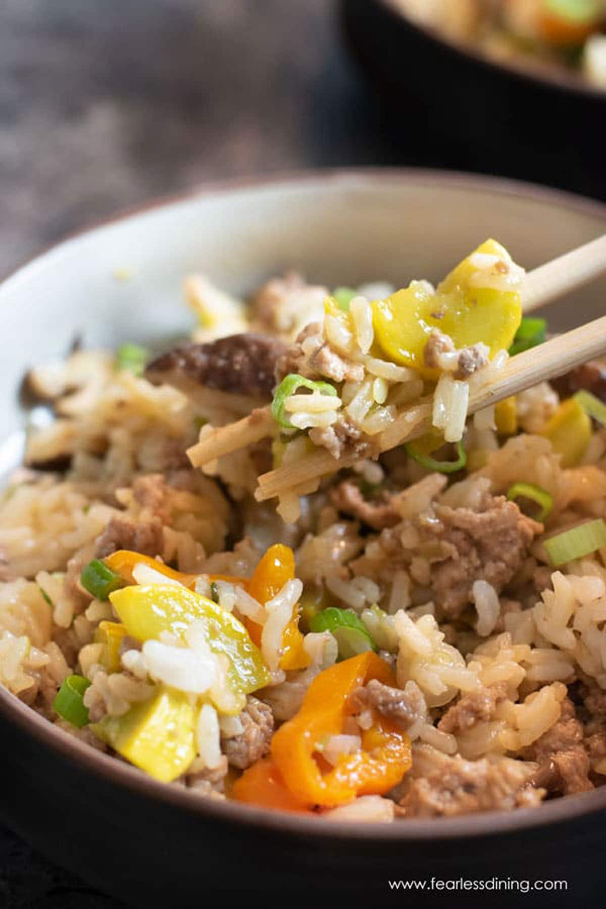 Holding up some of the fried rice between chopsticks.