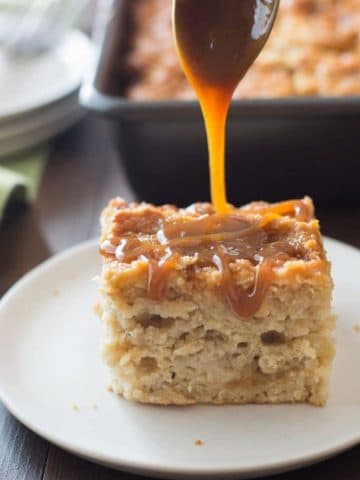 A slice of caramel apple cake with caramel being drizzled over the top.