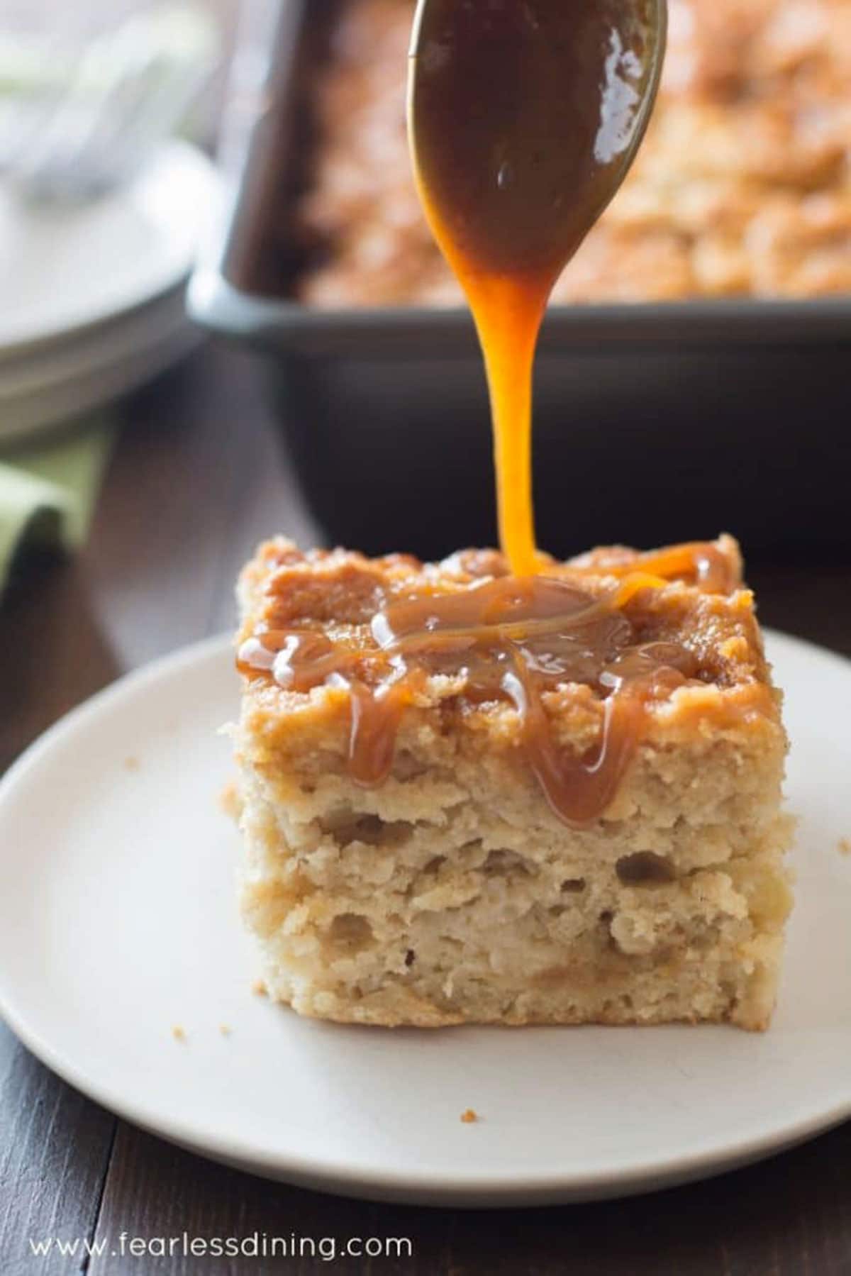 a slice of caramel apple cake with caramel being drizzled over the top