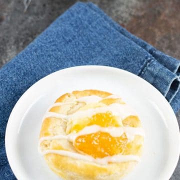 A gluten free cheese Danish on a small white plate.